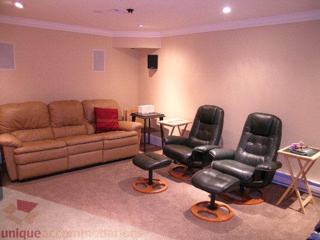 Living room with leather furniture and recliners, modern setup. - 405 - 4001 Mount Seymour Pkwy, North Vancouver