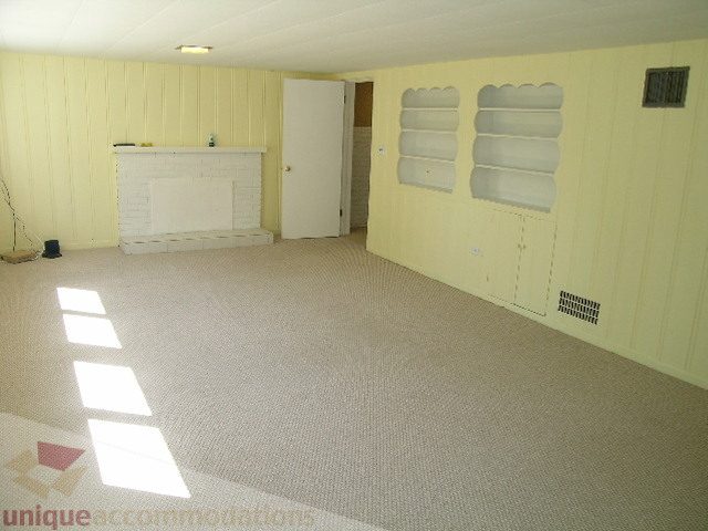 Bright living room with carpeted floors and a white fireplace. - 1350 14th Street, West Vancouver