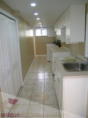 Bright kitchen with white cabinets, granite countertops, and tiled flooring. - 1350 14th Street, West Vancouver