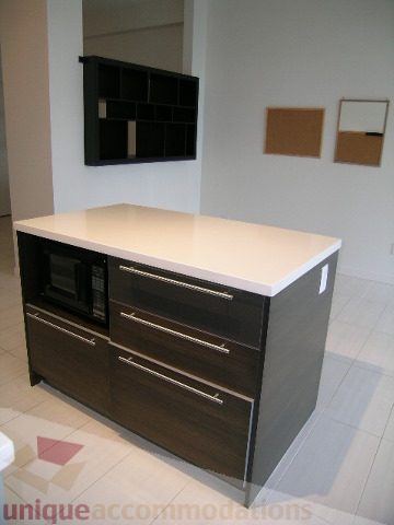 Bright kitchen with white countertops and dark wood cabinets. - 406 - 1252 Hornby Street, Vancouver Downtown