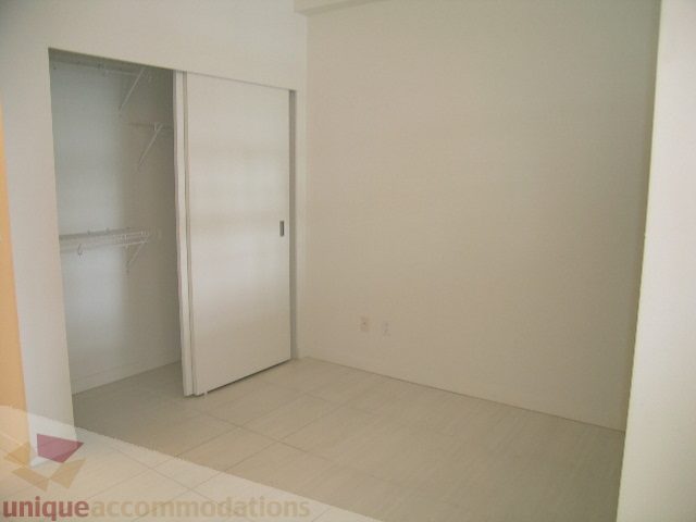 Bright bedroom with sliding closet doors and tiled floor. - 406 - 1252 Hornby Street, Vancouver Downtown