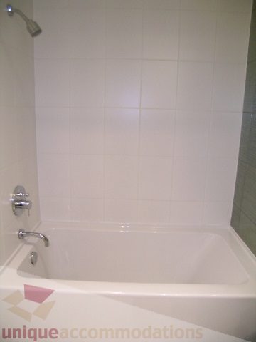 Bathroom with white tiles, modern fixtures, and a shower head. - 406 - 1252 Hornby Street, Vancouver Downtown