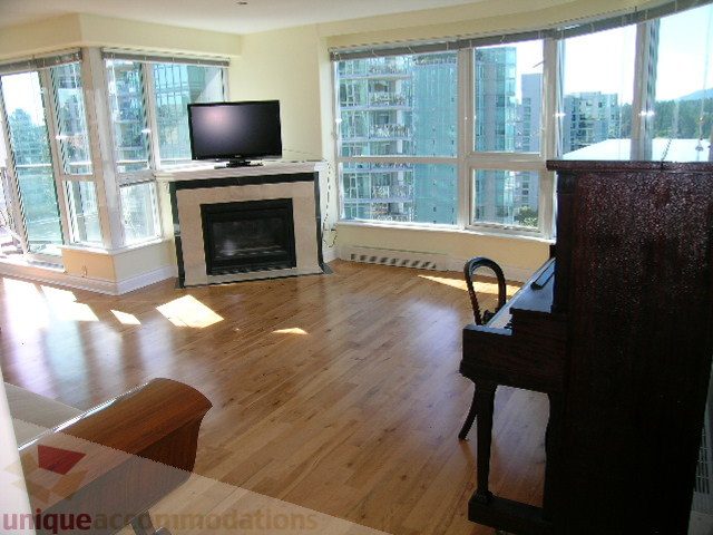 Furnished living room with hardwood floors, city view, and a fireplace. - 1602 - 560 Cardero, Vancouver Downtown