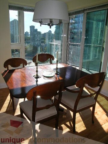 Bright dining area with wooden table, city view, and natural light. - 1602 - 560 Cardero, Vancouver Downtown