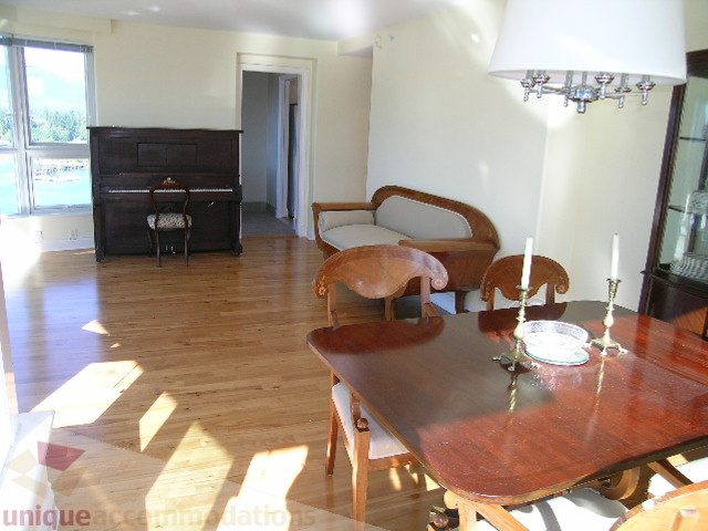 Furnished dining room with wooden table, chairs, and piano, hardwood floors, natural light. - 1602 - 560 Cardero, Vancouver Downtown