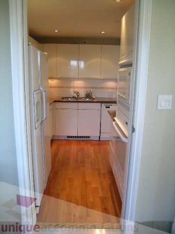 Bright kitchen with white cabinets, hardwood floors, and a stainless steel sink. - 1602 - 560 Cardero, Vancouver Downtown