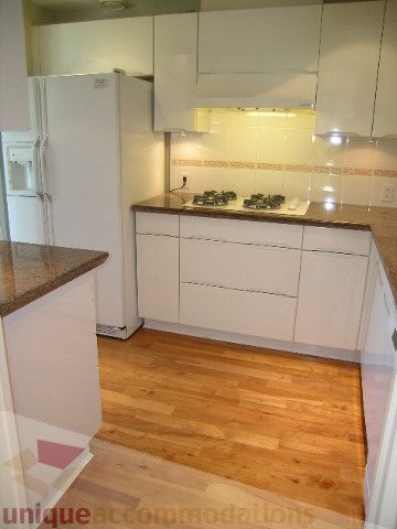 Bright kitchen with white cabinets, granite countertops, and hardwood floors. - 1602 - 560 Cardero, Vancouver Downtown