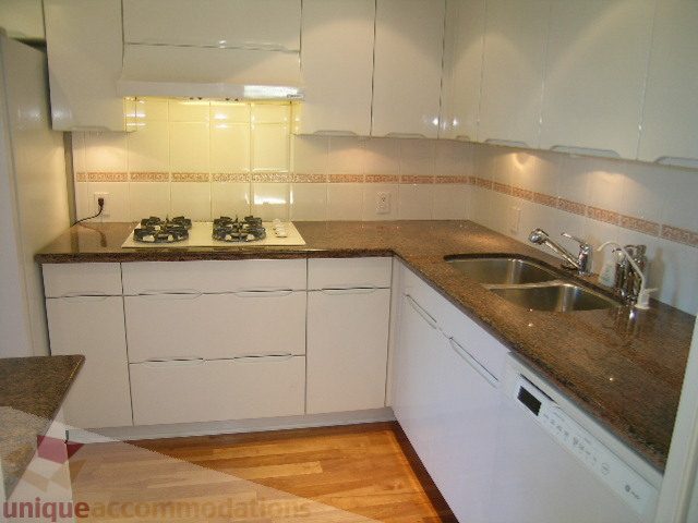 Bright kitchen with granite countertops, white cabinets, and hardwood floors. - 1602 - 560 Cardero, Vancouver Downtown