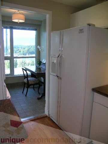 Bright kitchen with white appliances, hardwood floors, and a city view. - 1602 - 560 Cardero, Vancouver Downtown