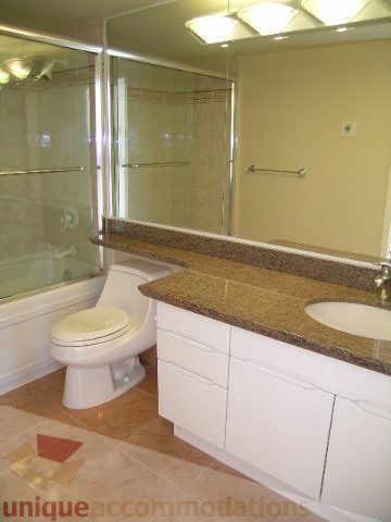 Bathroom with modern shower, granite countertops, and white cabinetry. - 1602 - 560 Cardero, Vancouver Downtown