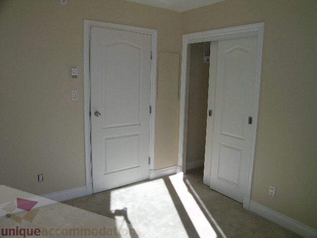 Bright bedroom with white doors and beige walls, natural light streaming in. - 1602 - 560 Cardero, Vancouver Downtown