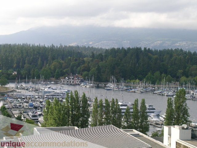 Bright living room with city view and marina, surrounded by lush greenery. - 1602 - 560 Cardero, Vancouver Downtown