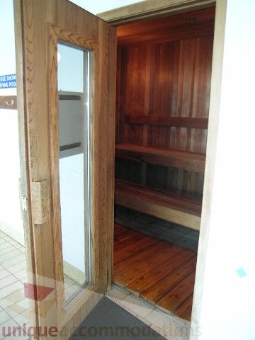 Den area with wooden shelving and hardwood floors, leading to a small balcony. - 1602 - 560 Cardero, Vancouver Downtown