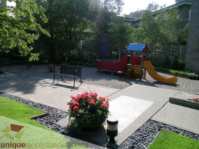 Furnished patio with vibrant flowers and playground equipment. - 1602 - 560 Cardero, Vancouver Downtown