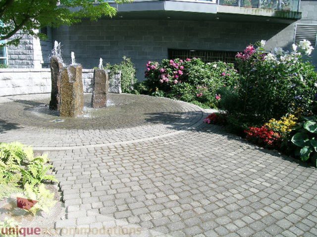 Furnished patio with stone fountain, pavers, and blooming flowers. - 1602 - 560 Cardero, Vancouver Downtown