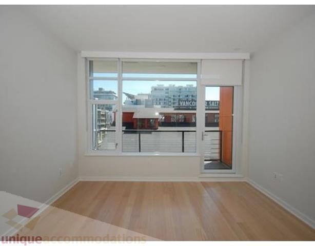 Spacious living room with hardwood floors, large windows, and a city view. - 504 - 123 West 1st Avenue, Vancouver West Side