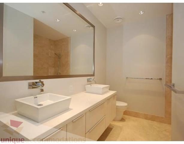 Modern bathroom with dual sinks, large mirror, and light wood cabinets. - 504 - 123 West 1st Avenue, Vancouver West Side