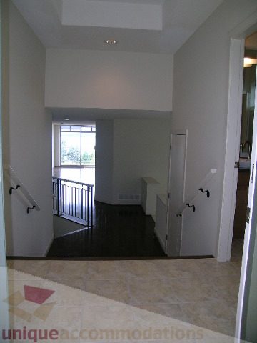 Spacious living area with high ceilings, hardwood floors, and a city view. - 8601 Seascape Place, West Vancouver