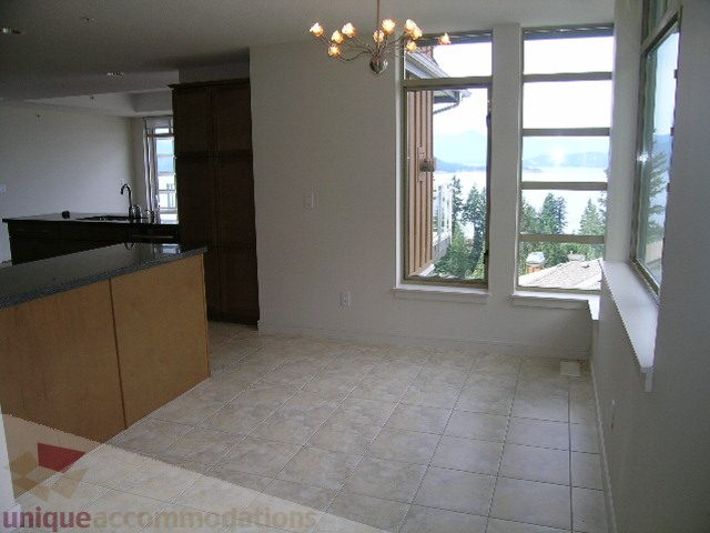 Spacious open-concept living area with large windows offering a stunning city view, featuring a modern chandelier and...