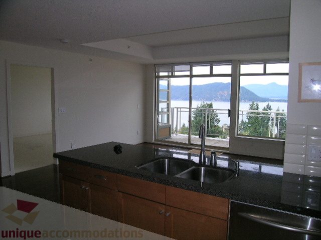 Spacious kitchen with granite countertops and a stunning city view. - 8601 Seascape Place, West Vancouver