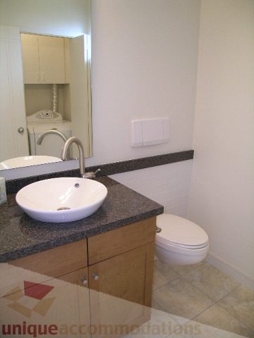 Modern bathroom with granite countertops and a sleek white sink. - 8601 Seascape Place, West Vancouver