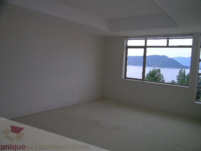 Spacious living room with a stunning view of the mountains and water, perfect for relaxing. - 8601 Seascape Place, West Vancouver
