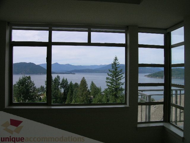 Spacious living room with stunning ocean view and large windows. - 8601 Seascape Place, West Vancouver