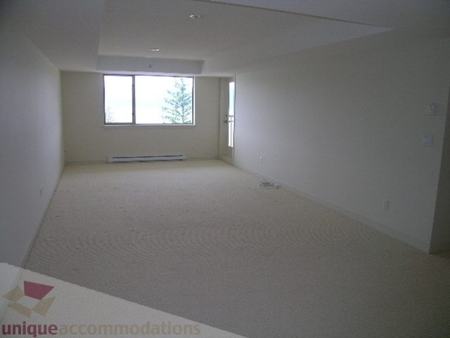 Spacious bedroom with large window and textured carpet, perfect for relaxation. - 8601 Seascape Place, West Vancouver