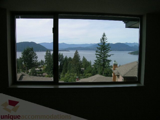 Spacious living room with stunning views of the mountains and water, perfect for relaxation. - 8601 Seascape Place, West Vancouver