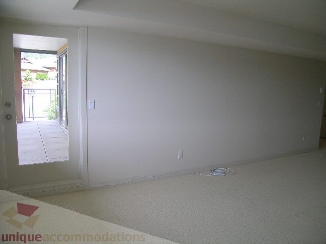 Spacious living room with neutral carpet and sliding glass door leading to patio. - 8601 Seascape Place, West Vancouver