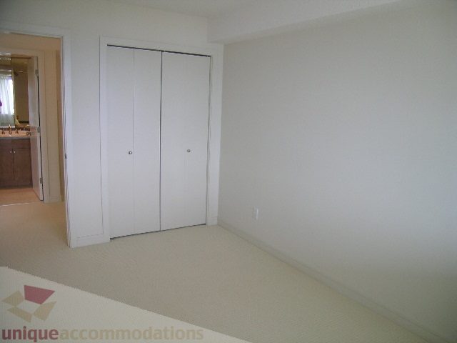 Spacious bedroom with built-in closet and carpeted floor. - 8601 Seascape Place, West Vancouver
