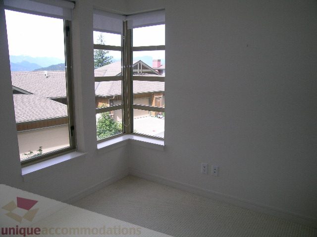 Spacious bedroom with large windows offering a stunning city view. - 8601 Seascape Place, West Vancouver