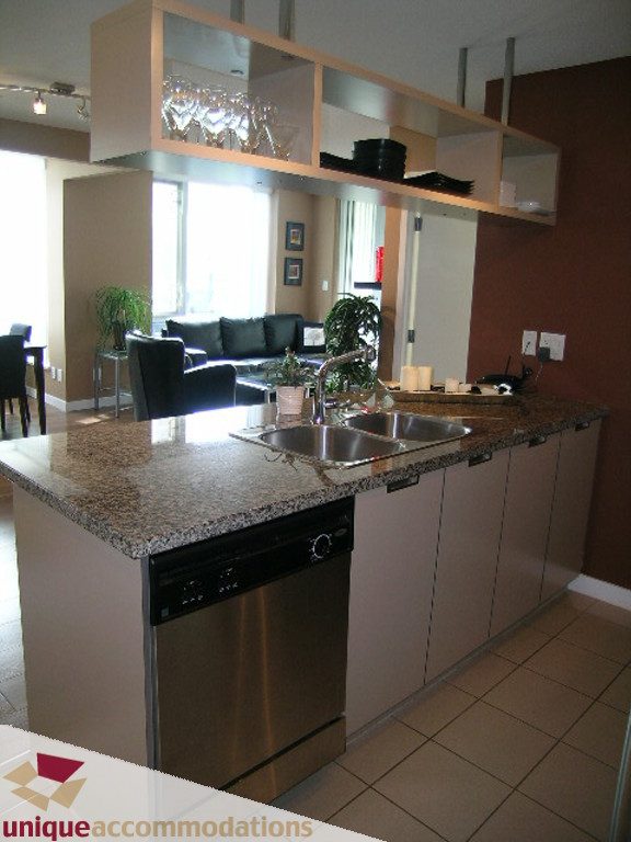Bright kitchen with granite countertops, stainless steel sink, and open shelving above. - 316 - 1082 Seymour, Vancouver Downtown
