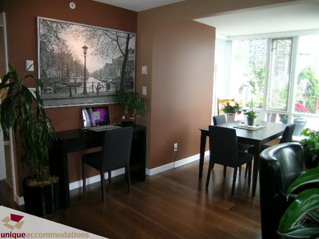Furnished dining area with hardwood floors, city view, and modern decor. - 316 - 1082 Seymour, Vancouver Downtown