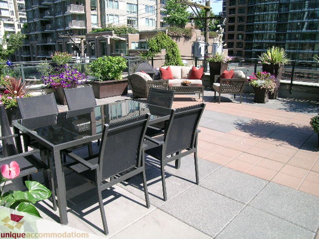 Furnished patio with outdoor furniture, city view, and potted plants. - 316 - 1082 Seymour, Vancouver Downtown