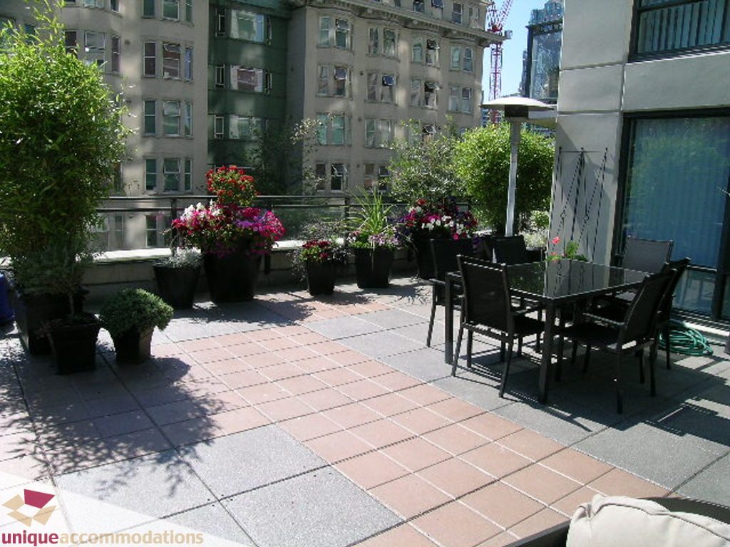 Furnished patio with potted plants and outdoor seating, city view in background. - 316 - 1082 Seymour, Vancouver Downtown