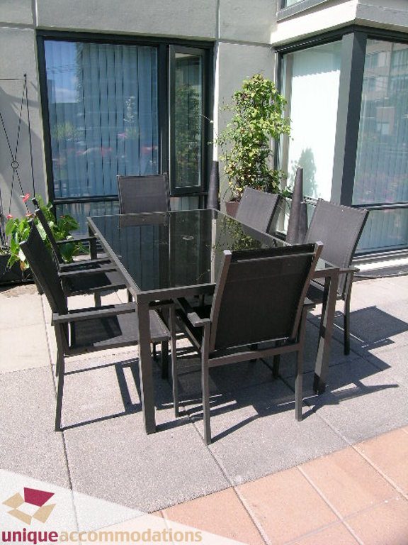 Furnished patio with glass table and black chairs, modern design. - 316 - 1082 Seymour, Vancouver Downtown