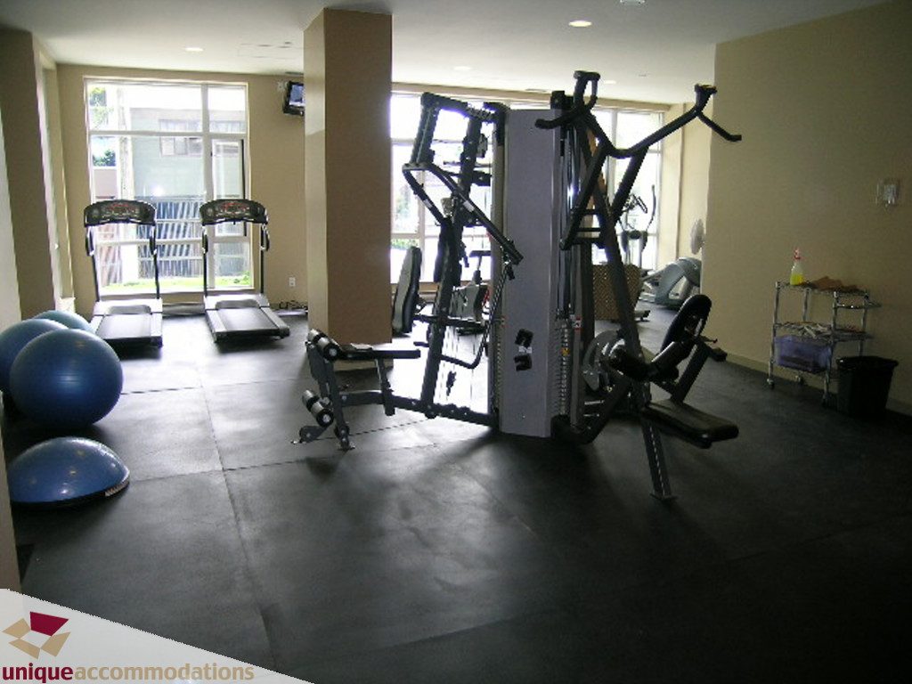 Bright fitness room with cardio machines and exercise balls, large windows offering city views. - 316 - 1082 Seymour, Vancouver Downtown