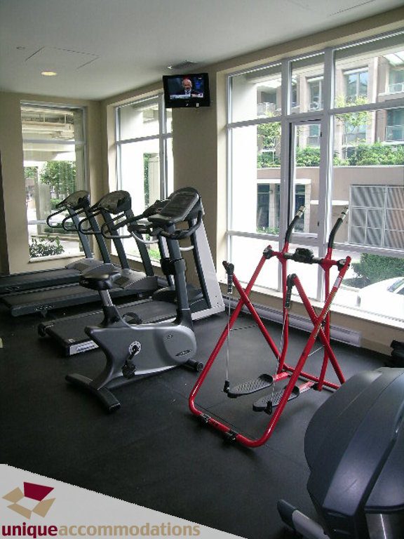 Bright gym with treadmills, elliptical, and city view windows. - 316 - 1082 Seymour, Vancouver Downtown