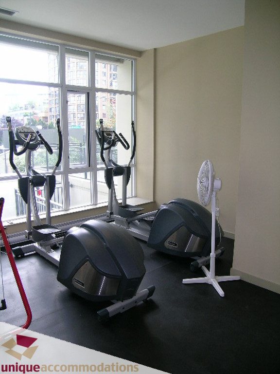 Bright exercise room with city view, cardio equipment, and fan. - 316 - 1082 Seymour, Vancouver Downtown