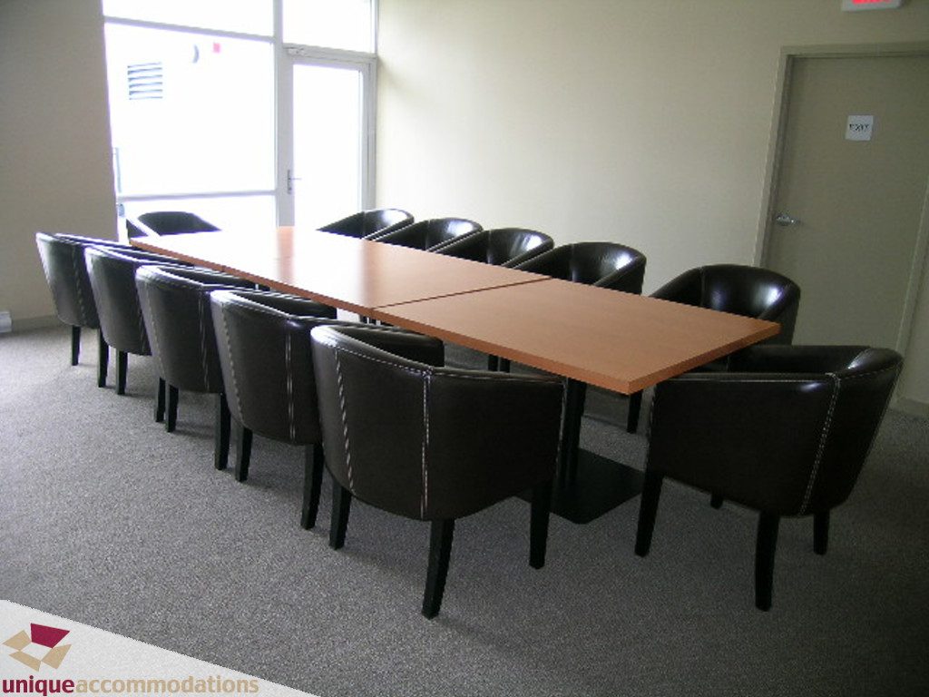Meeting room with long wooden table and black leather chairs, natural light from large windows. - 316 - 1082 Seymour, Vancouver Downtown