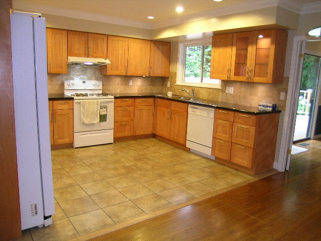 Bright kitchen with wooden cabinets, granite countertops, and hardwood floors. - 992 Canyon Blvd, North Vancouver