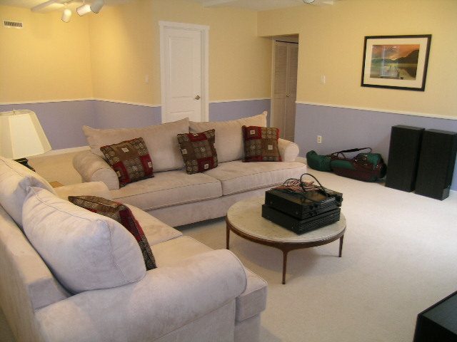 Bright living room with beige couches, patterned throw pillows, and a modern coffee table. - 992 Canyon Blvd, North Vancouver