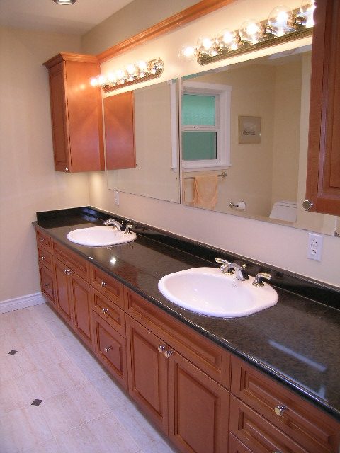Double sink vanity with granite countertop and wooden cabinets. - 992 Canyon Blvd, North Vancouver