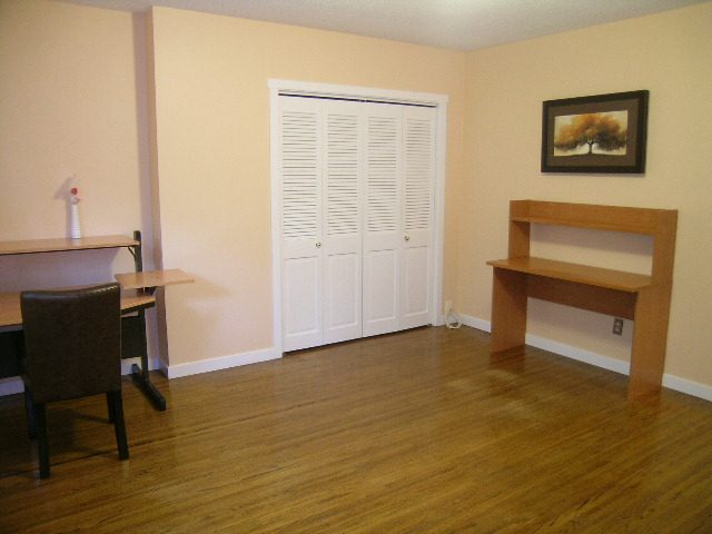 Bright living room with hardwood floors and a wooden bench. - 992 Canyon Blvd, North Vancouver