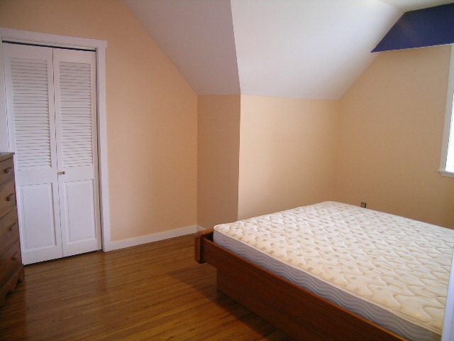 Bright bedroom with hardwood floors and a large closet. - 992 Canyon Blvd, North Vancouver