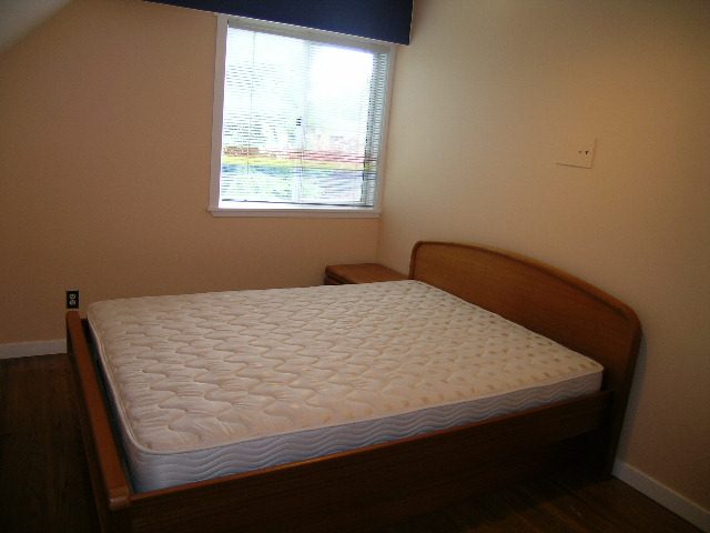 Bright bedroom with wooden floors and a window view. - 992 Canyon Blvd, North Vancouver