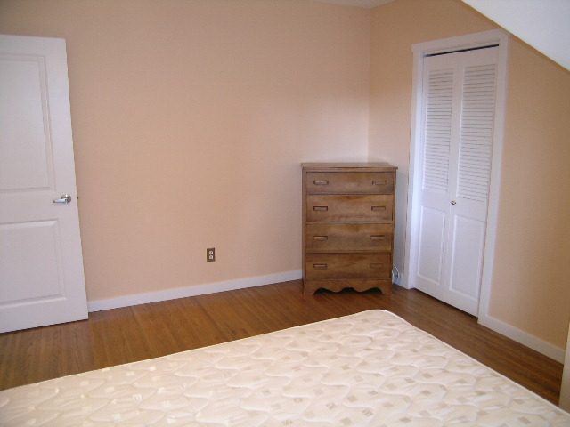 Bedroom with hardwood floors and a simple dresser. - 992 Canyon Blvd, North Vancouver