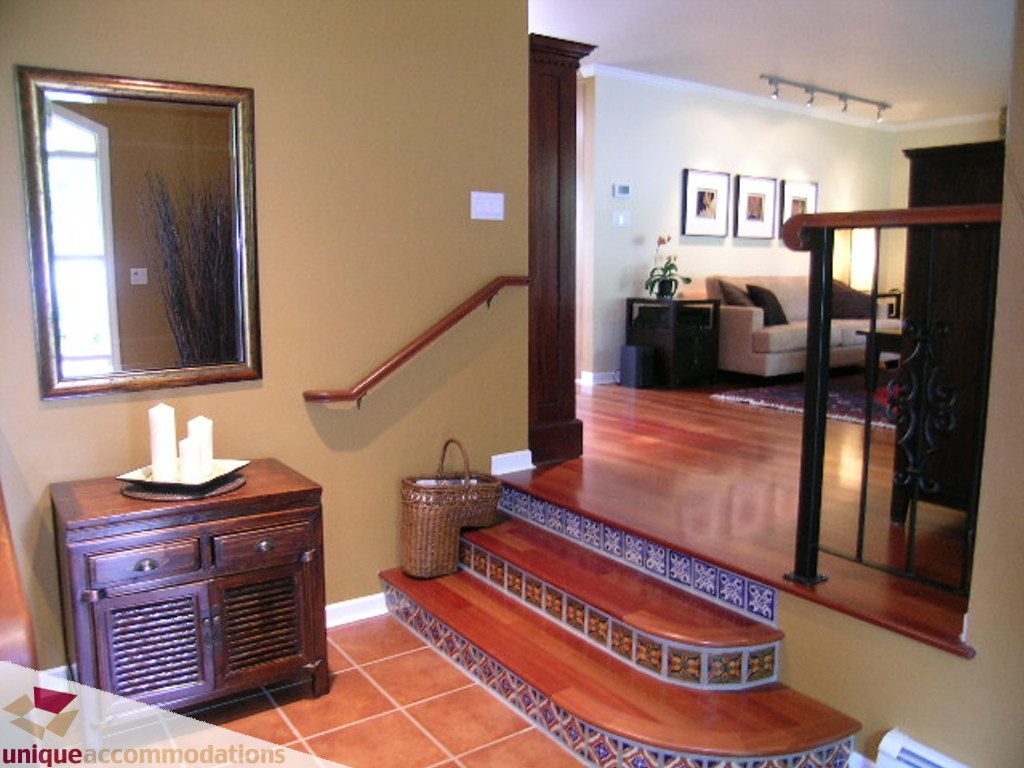 Furnished living room with wooden staircase and decorative tile steps. - 1385 East 15th Street, North Vancouver