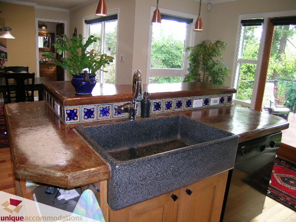 Bright kitchen with granite countertops, wooden cabinets, and a view of greenery outside. - 1385 East 15th Street, North Vancouver